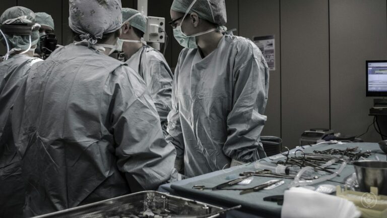 Surgical team in an operating room, illustrating research on higher pump flow and pulsatile perfusion during cardiopulmonary bypass